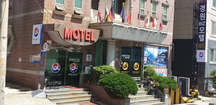 'MOTEL' 입체 글자와 세로 간판이 있는 건물 정면 입구